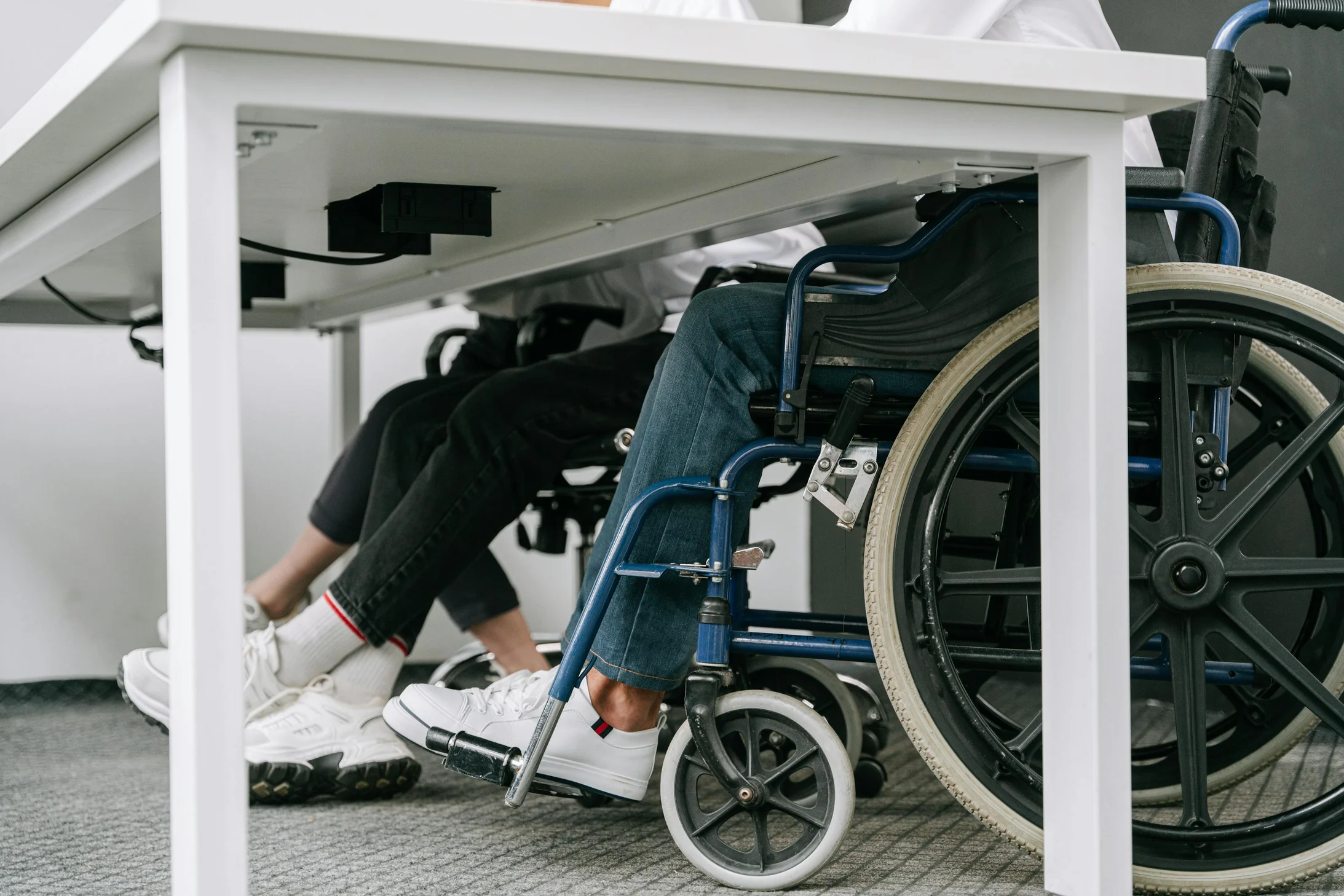 Business setting featuring people working with wheelchair accessibility indoors.
