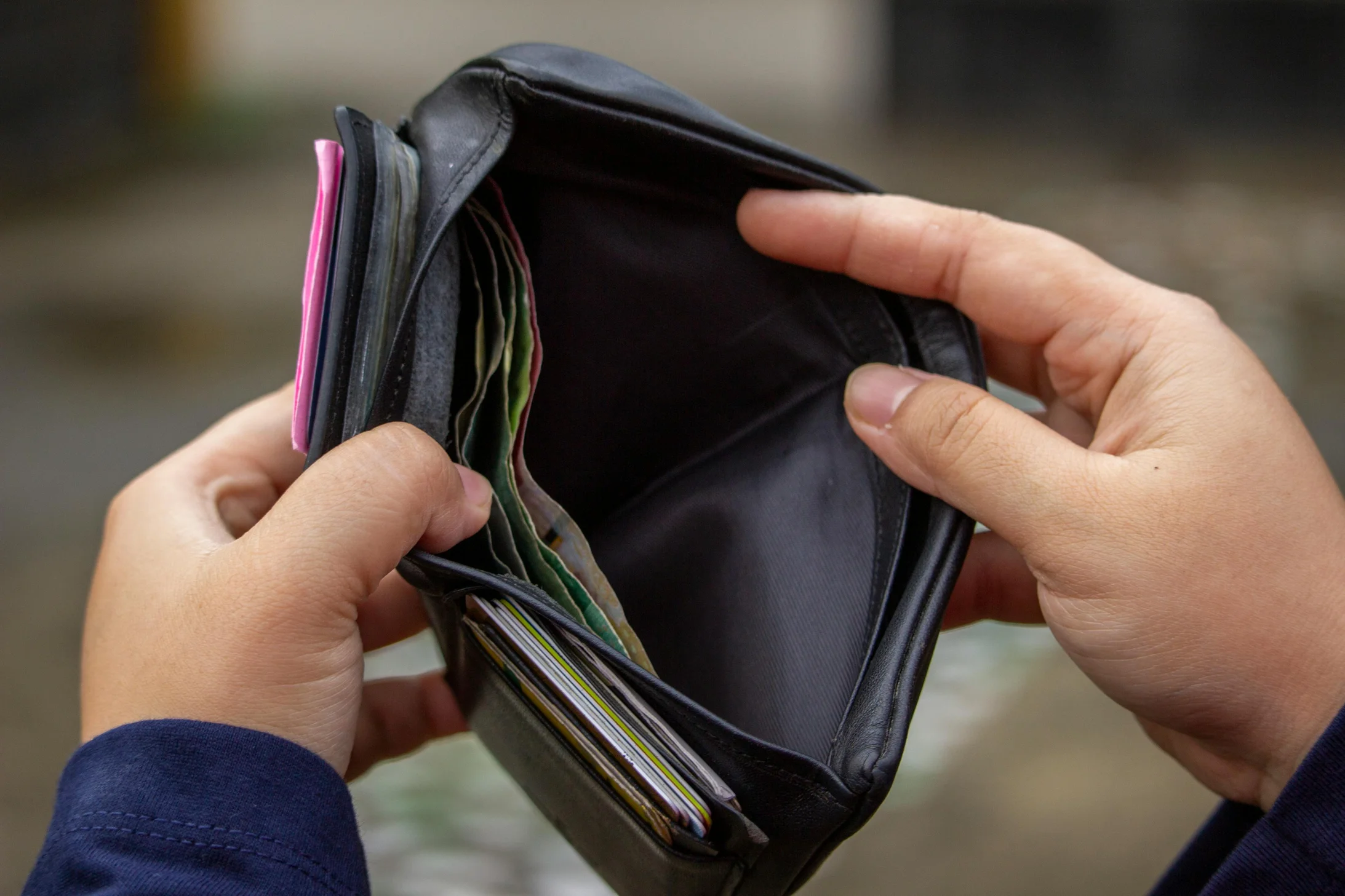 Hands holding an empty wallet, exploring themes of financial strain and budgeting.