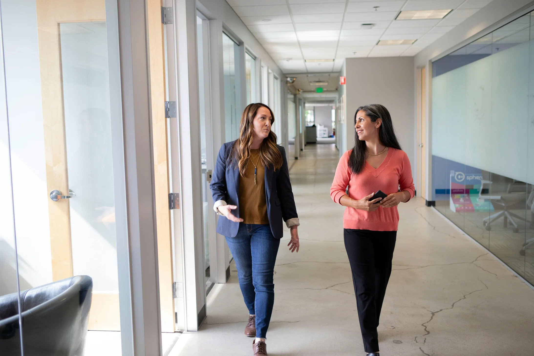 Women talking while walking on hallway