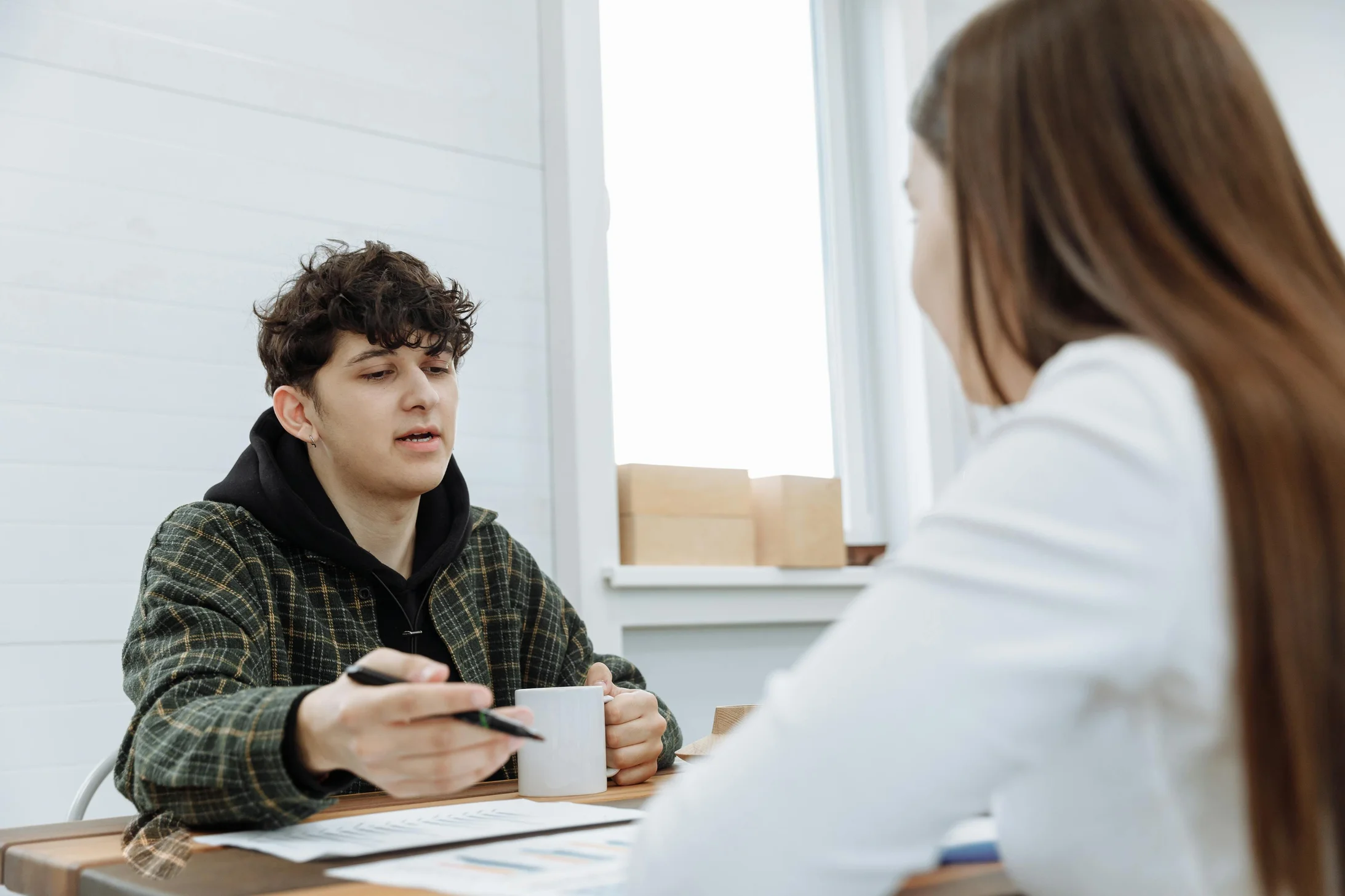 Two colleagues having a relaxed discussion in a modern office space.