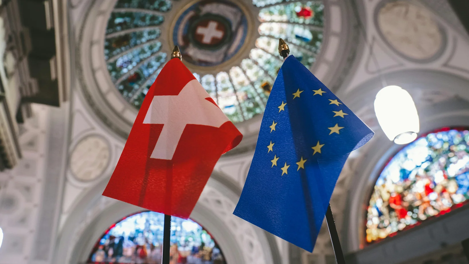 Switzerland and europian flags under a stained glass ceiling