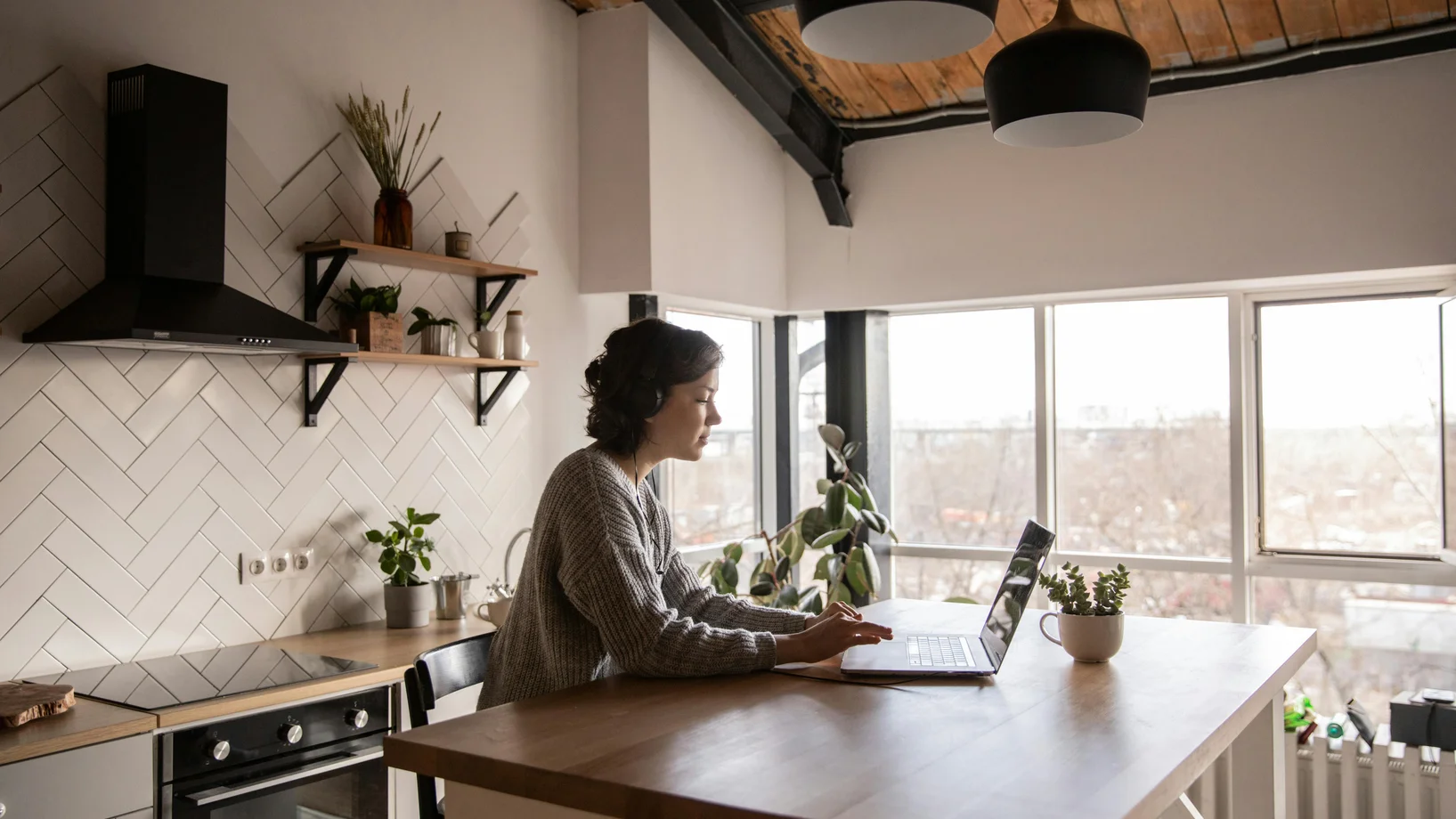 Young woman surfing laptop in kitchen