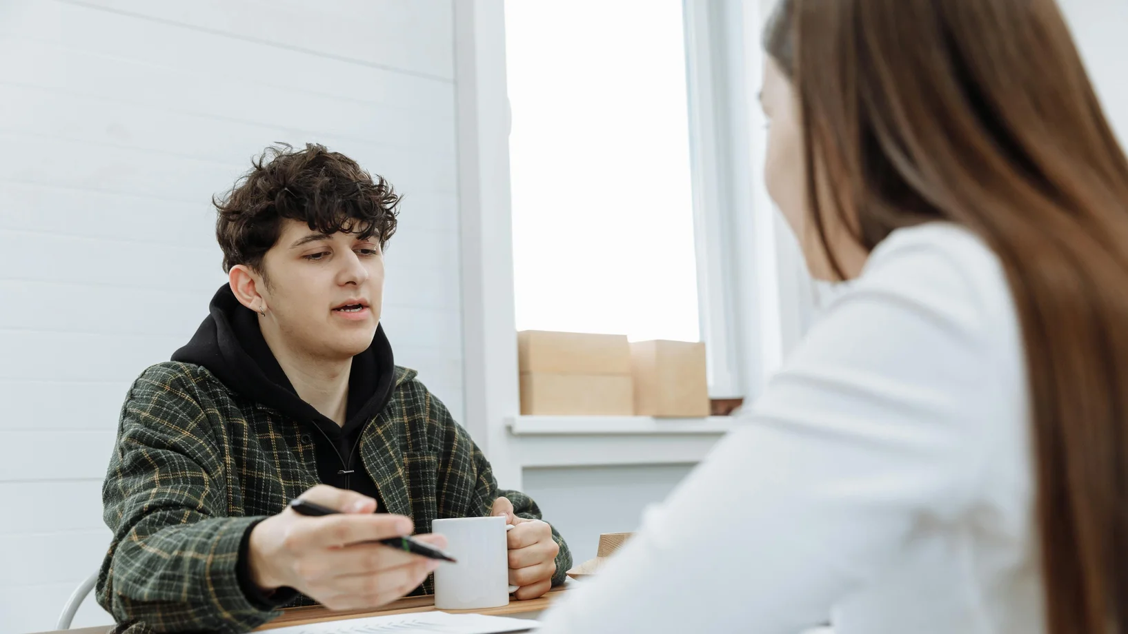 Two colleagues having a relaxed discussion in a modern office space.