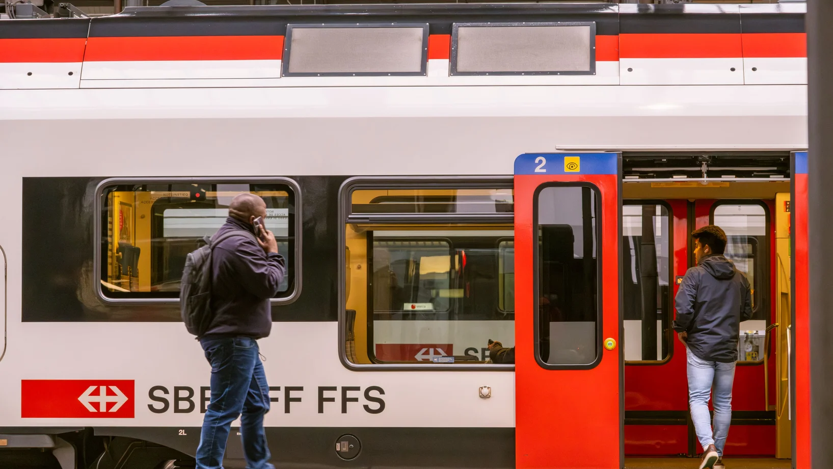 Travelers boarding an SBB train at the Lucerne railway station in Switzerland.